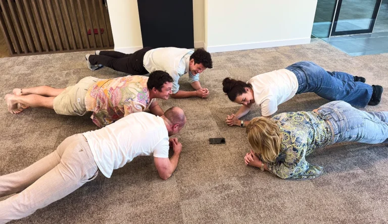 Wincent team members holding a plank on the office floor
